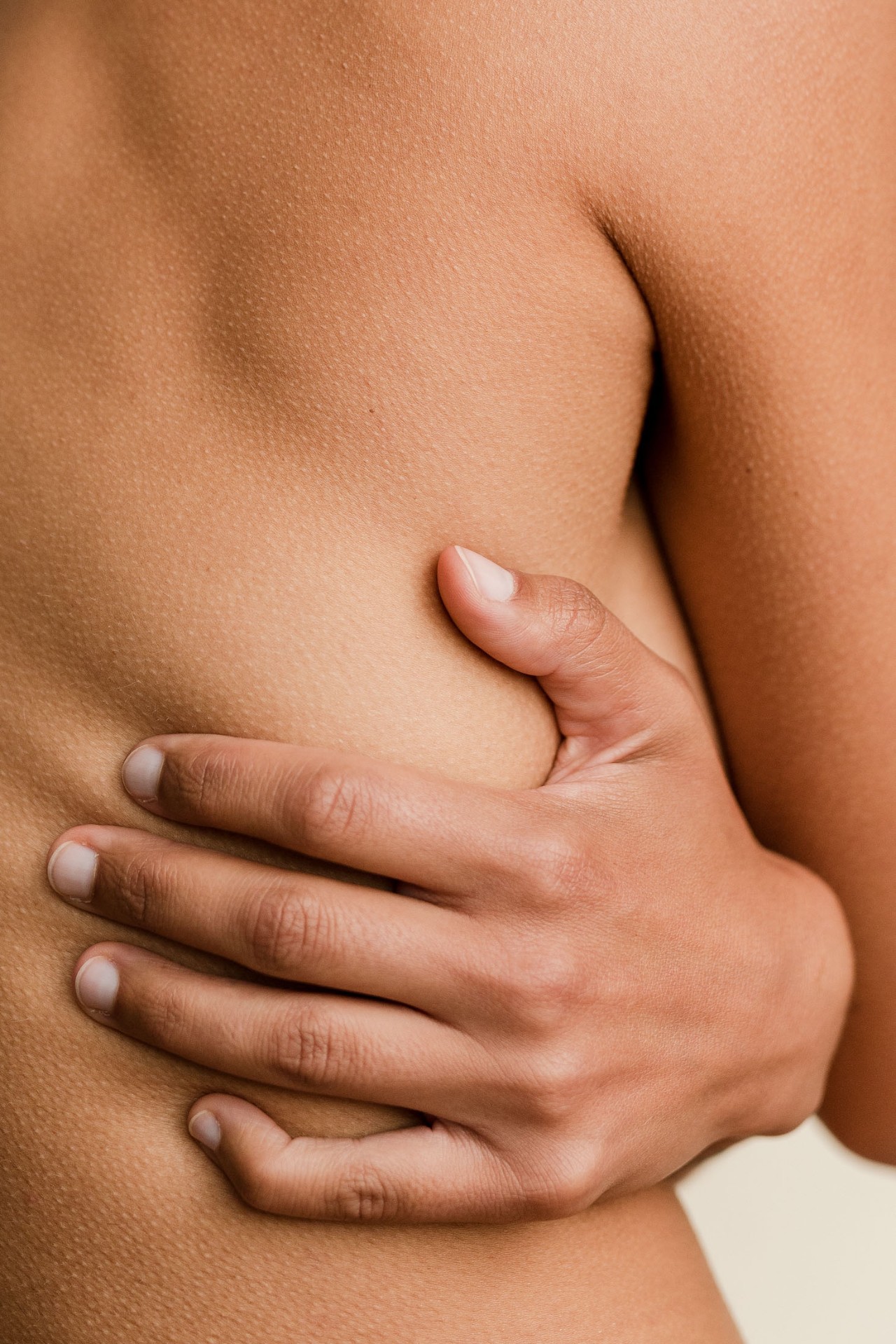 A hand resting against the torso — a quiet self-embrace